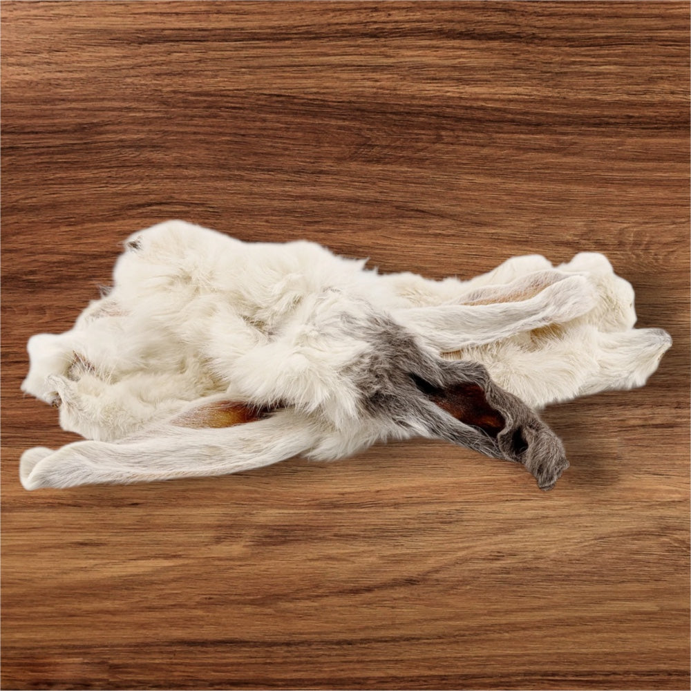 Hilltop Pet Foodβs Furry Rabbit Ears, in white and gray, rest subtly on a wooden surface.