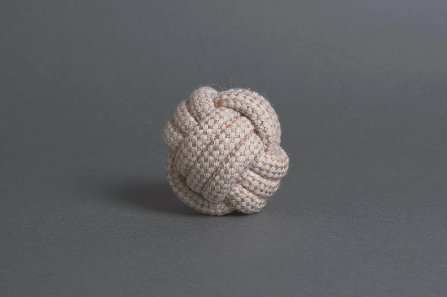 The Hilltop Pet Food Natural Rope Toy - Classic Rope Ball sits on a plain gray surface and background.