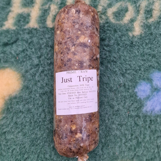 A roll of Hilltop Pet Food Prime:Raw - Just Tripe for working dogs rests on a green surface, label and instructions visible.