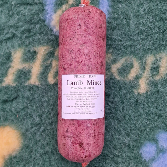 A roll of Hilltop Pet Food Prime:Raw - Lamb Complete on a patterned blue and yellow surface with a white label.