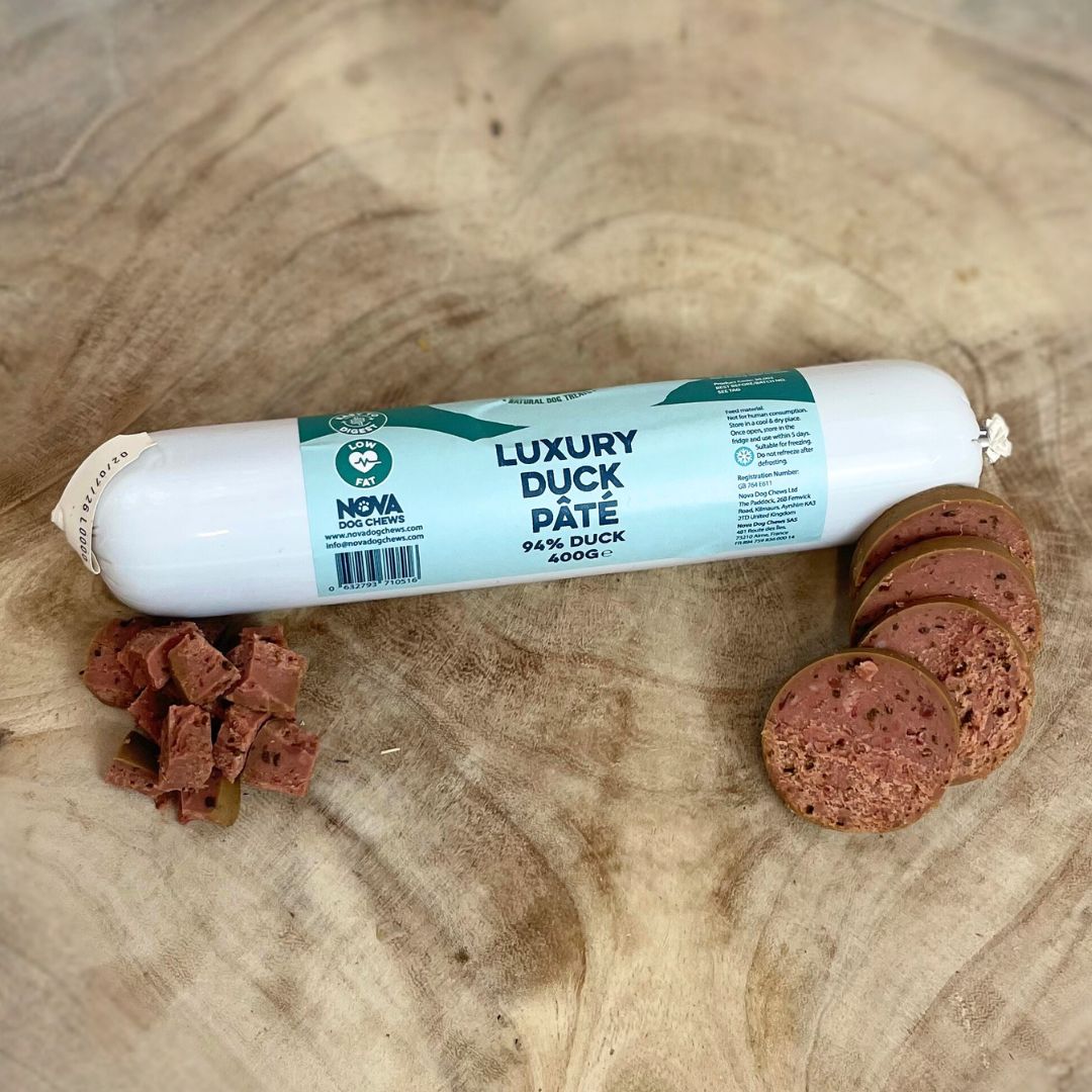 Hilltop Pet Food Paddock Farm Luxury Pâté for dogs and cats, with round slices and cubes, shown on wood.