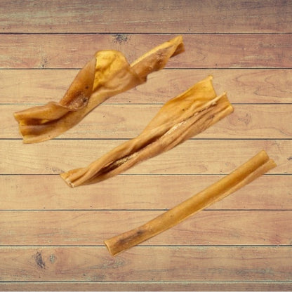 Three pieces of dried Goat Skin dog treats on a wooden surface