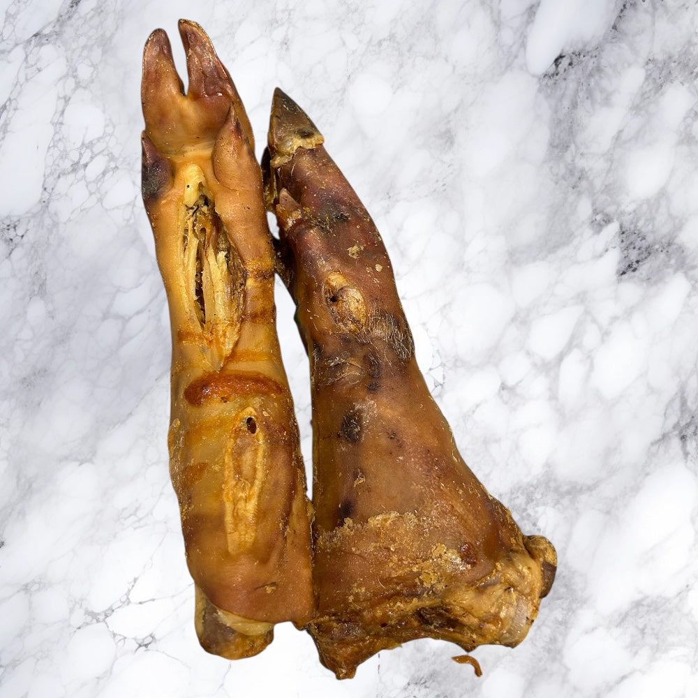 Two Hilltop Pet Food Large Pig Trotter - Dried treats on marble, ideal for long-lasting dog enjoyment.