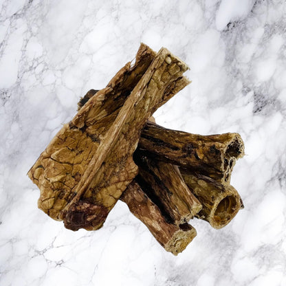 Five pieces of Hilltop Pet Food Puffed Beef Jerky (Lung) are stacked on a white marble surface.