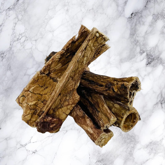 Five pieces of Hilltop Pet Food Puffed Beef Jerky (Lung) are stacked on a white marble surface.