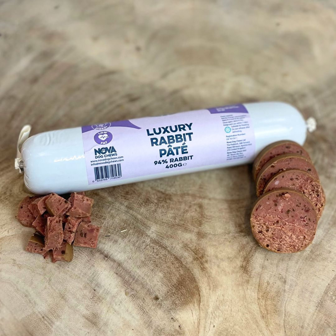 Hilltop Pet Foods Paddock Farm Luxury Pâté for dogs and cats, with slices and cubes on a wooden surface.