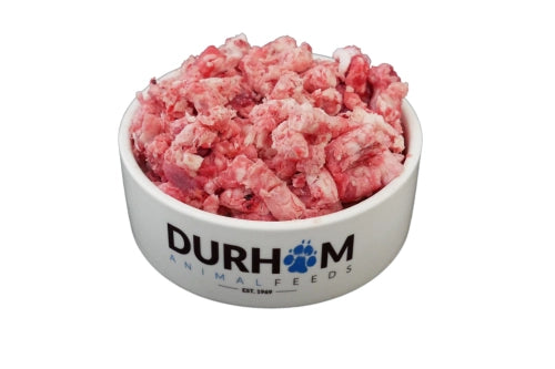 A Hilltop Pet Food Durham Beef Complete Mince 454g bowl filled with frozen dog food, isolated on white background.