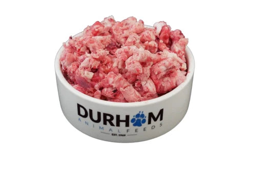 A bowl labeled Hilltop Pet Food filled with Duck Complete Mince 454g chunks and frozen raw dog food.