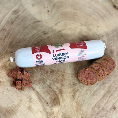 Hilltop Pet Foods Paddock Farm Luxury Pâté for dogs and cats, with slices and cubes on a wooden surface.