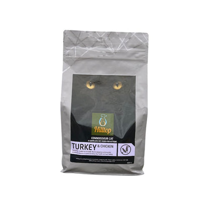 A gray Hilltop Pet Food Connoisseur Cat Food Adult - Turkey & Chicken bag featuring a cats eyes on the front.