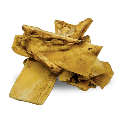 Several yellowish-brown Hilltop Pet Food Beef Skin Chews stacked against a white background.