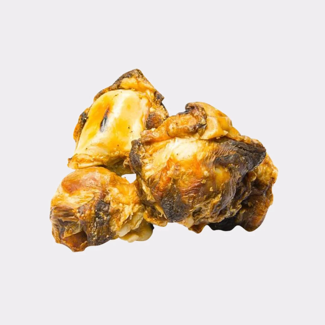 Three Hilltop Pet Food Beef Knees - Doggy Gobstoppers are stacked on a white background as a natural dog chew.