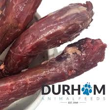 Three Hilltop Pet Food Raw Duck Necks (1kg) in a bowl; natural toothbrushes for dogs. Durham logo bottom right.