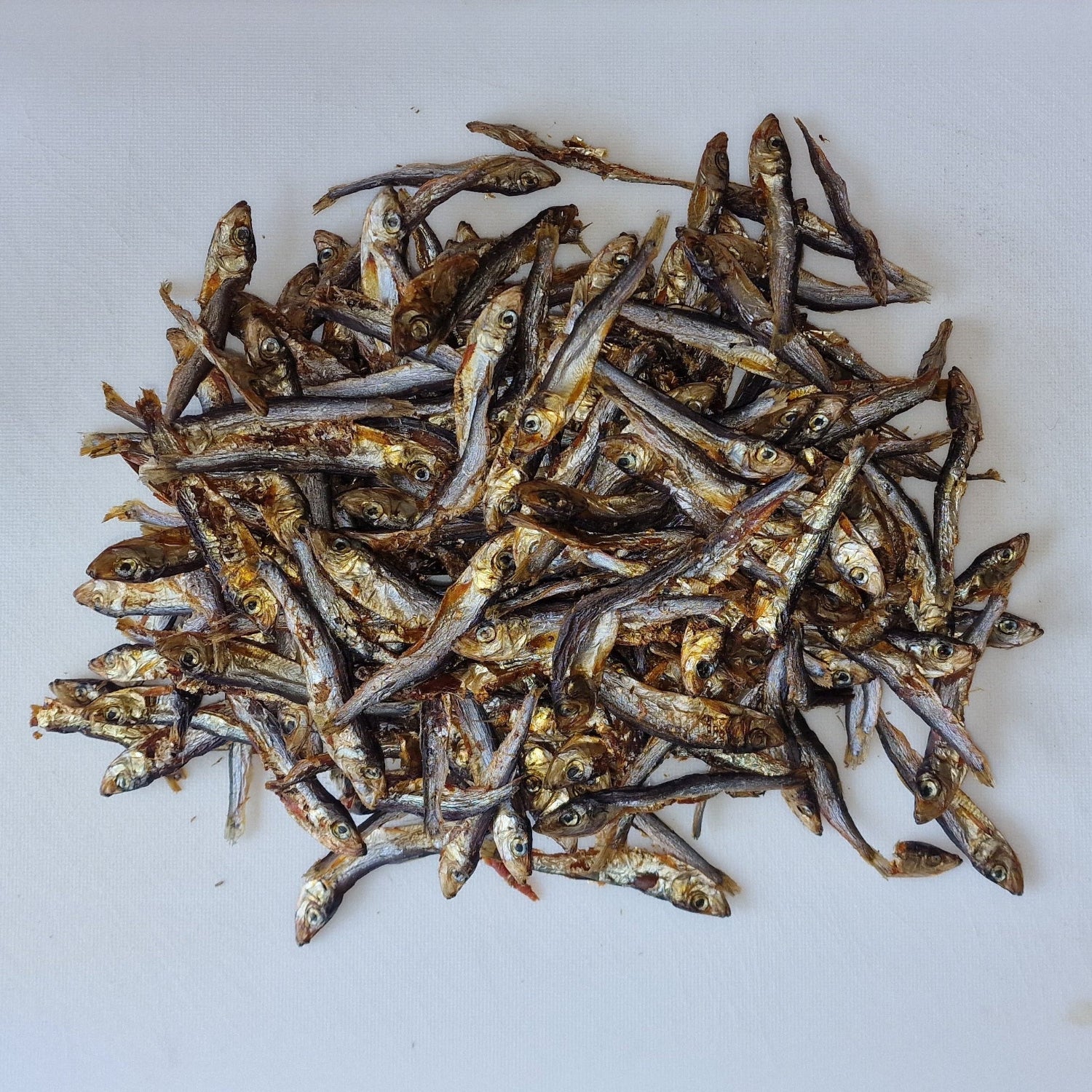 Dried sprats on a white cutting board