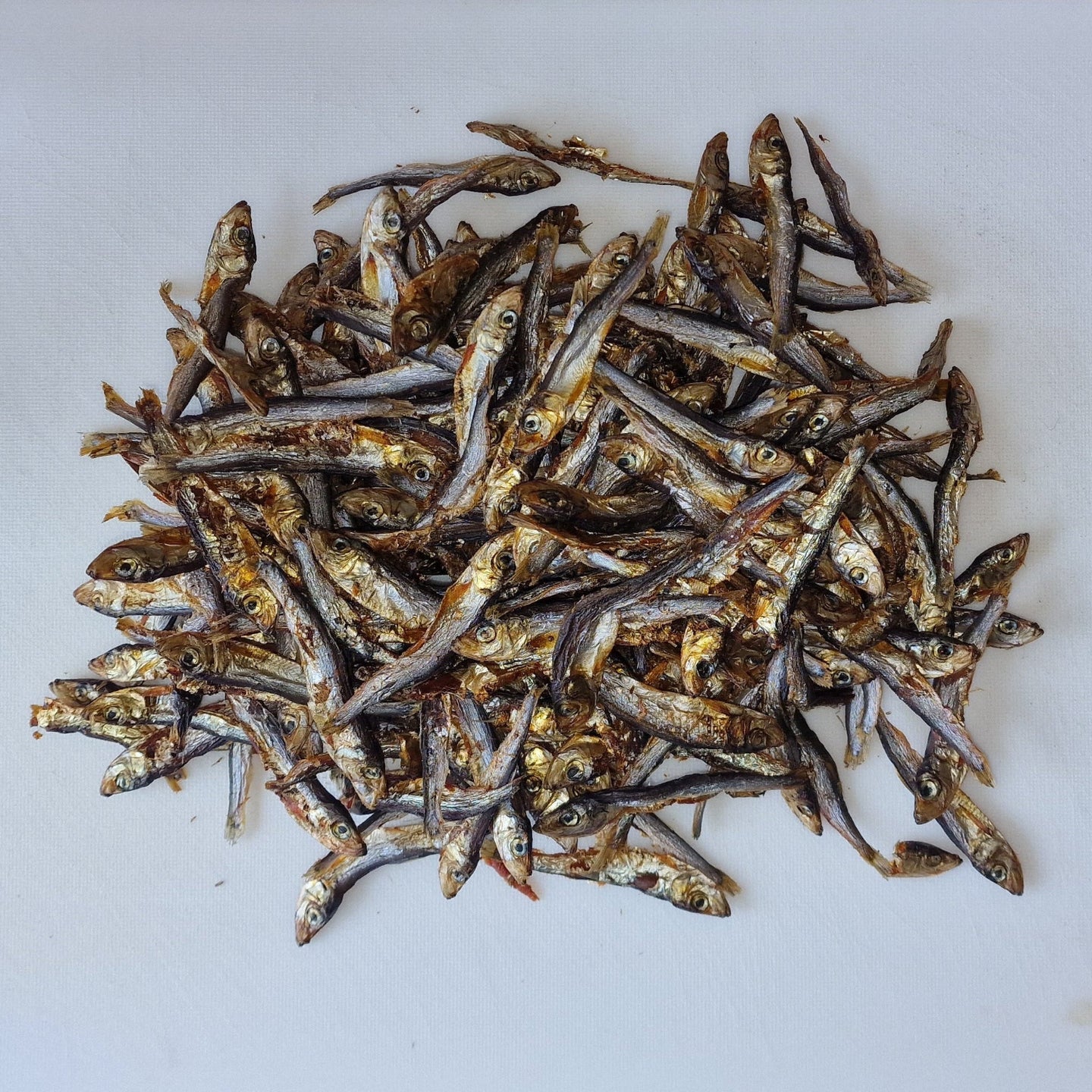 Dried sprats on a white cutting board