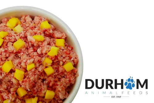 Dog food with yellow chunks in a bowl, branded with Durham Animal Feeds.