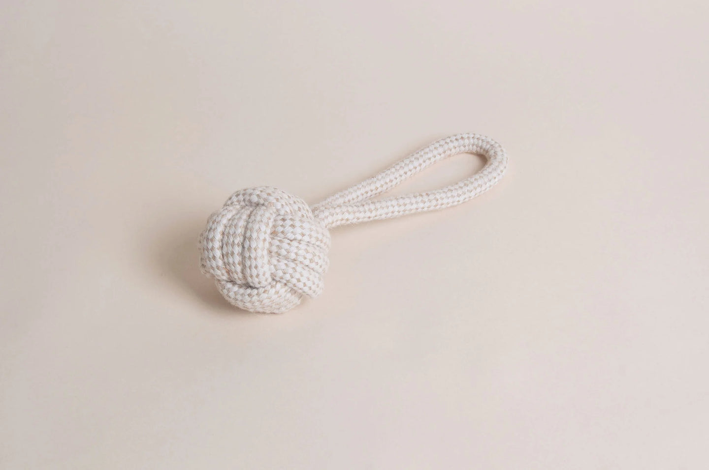 The Hilltop Pet Food Natural Rope Toy - Slingshot Ball features a knotted ball and looped handle on beige.