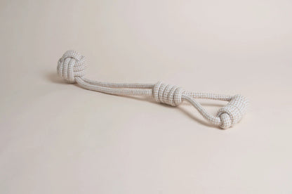 The Hilltop Pet Food Natural Rope Toy - Swingball Tug, white and gray with large end knots, sits on a light surface.