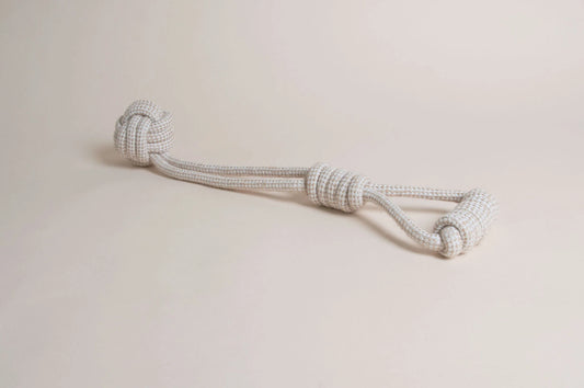 The Hilltop Pet Food Natural Rope Toy - Swingball Tug, white and gray with large end knots, sits on a light surface.