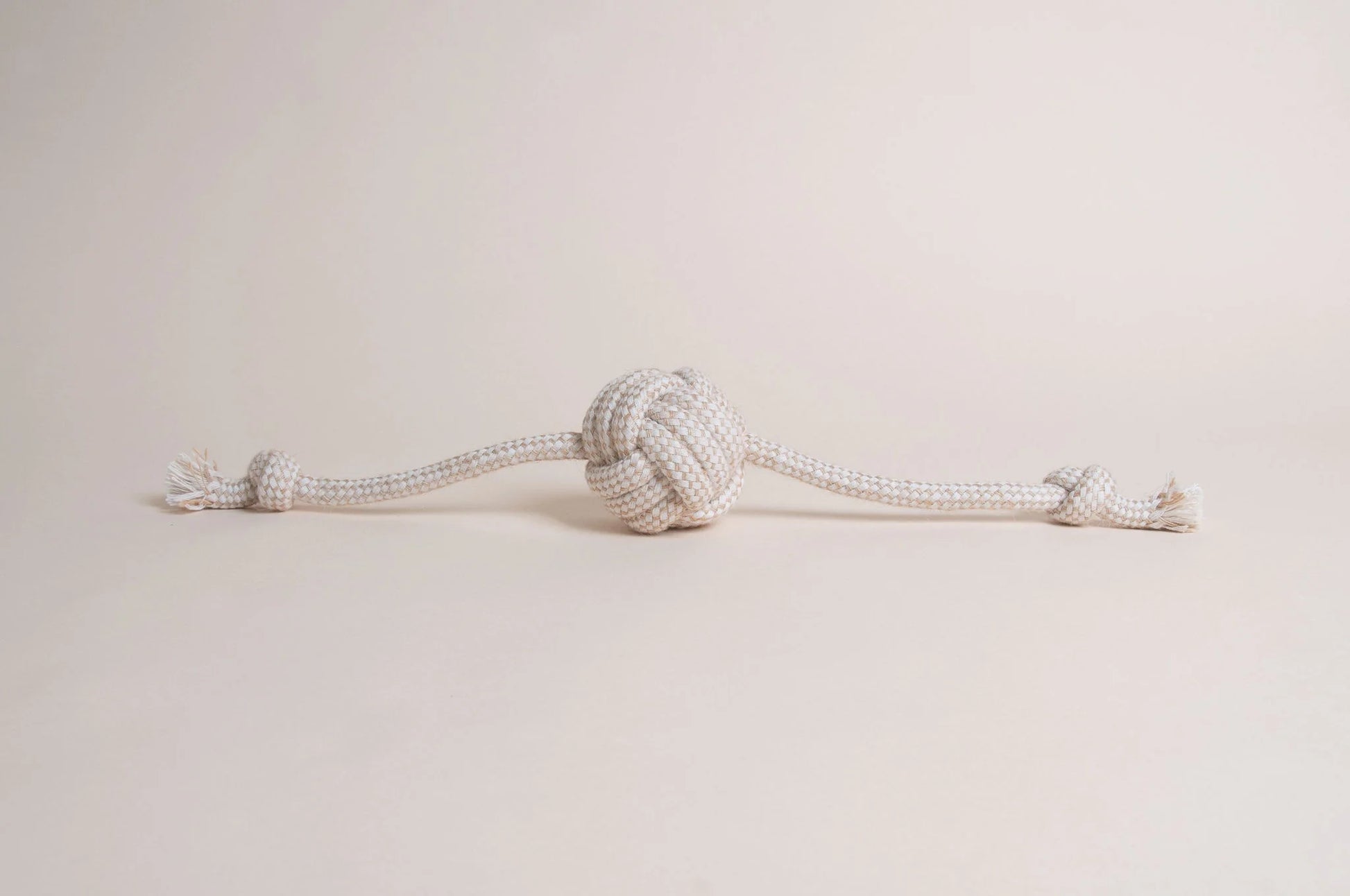 The Hilltop Pet Food Natural Rope Toy - Flail Ball is an eco-friendly knotted rope with a center ball and end knots.