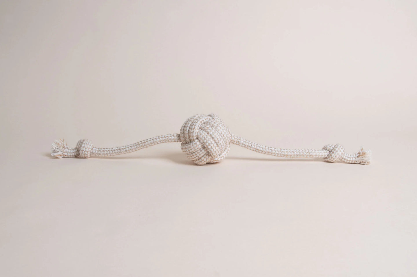 The Hilltop Pet Food Natural Rope Toy - Flail Ball is an eco-friendly knotted rope with a center ball and end knots.