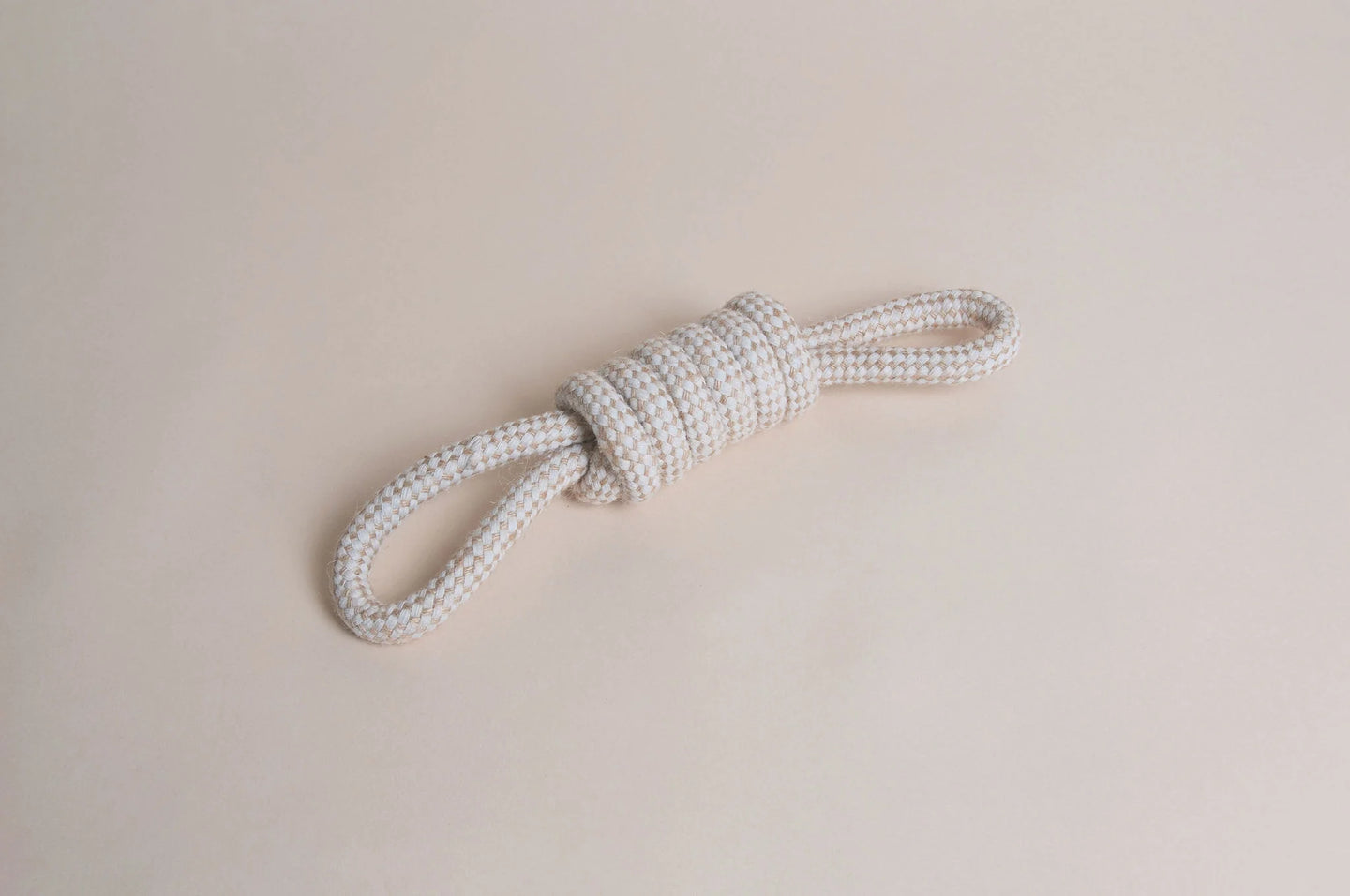 Hilltop Pet Food’s Natural Rope Toy - Bow Tie Tug, tied in a knot, shown on a light beige background.