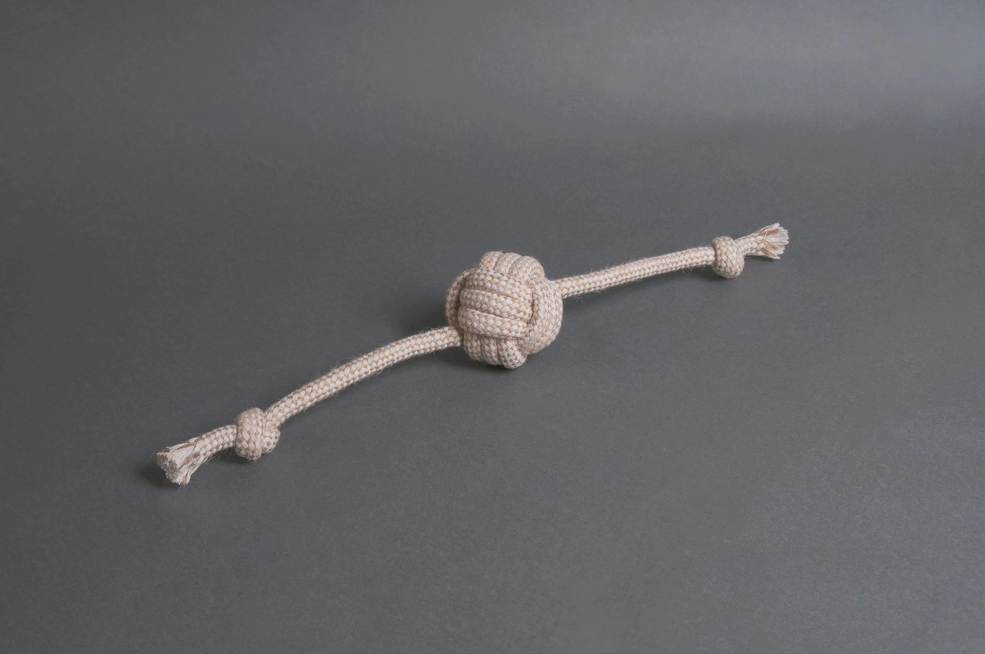 Hilltop Pet Foods Natural Rope Toy - Flail Ball in beige with frayed ends on a plain gray background.