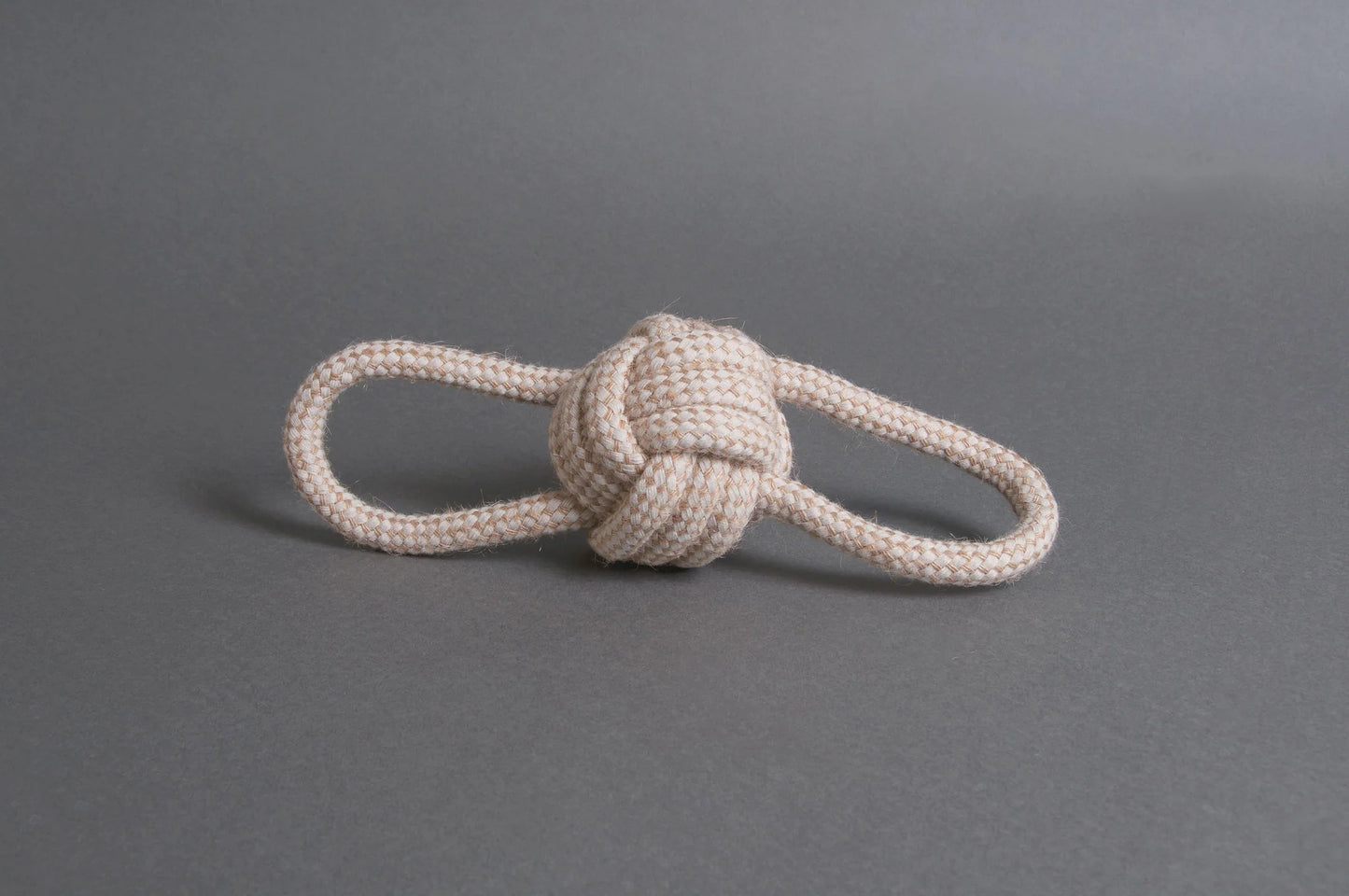 Hilltop Pet Foods Natural Rope Toy - Bow Tie Ball in white, featuring two loops, on a plain gray surface.