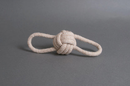 Hilltop Pet Foods Natural Rope Toy - Bow Tie Ball in white, featuring two loops, on a plain gray surface.