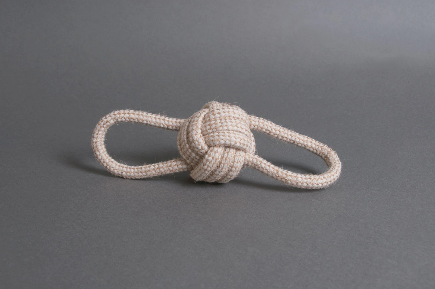 Hilltop Pet Foods Natural Rope Toy - Bow Tie Ball in white, featuring two loops, on a plain gray surface.