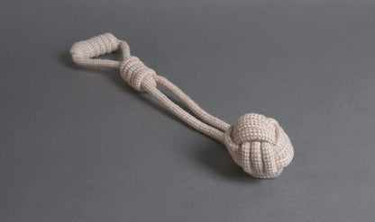 The Hilltop Pet Food Natural Rope Toy - Swingball Tug, in beige, is shown on a gray surface.
